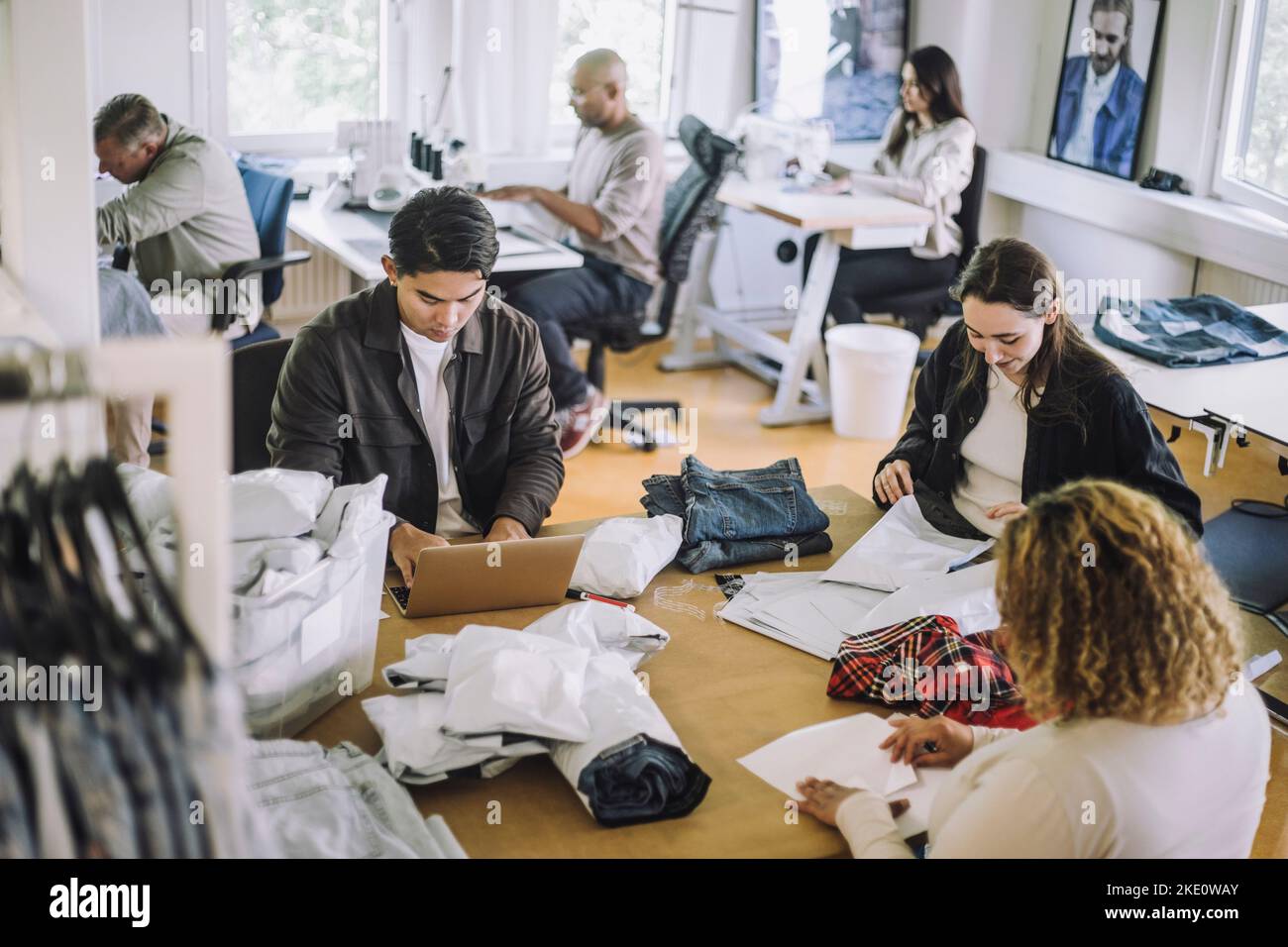 Vista ad angolo alto dei designer di moda che lavorano insieme in officina Foto Stock