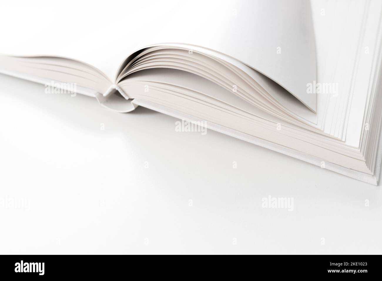 vista ravvicinata di una pagina vuota libro hardback aperto sulla scrivania bianca Foto Stock