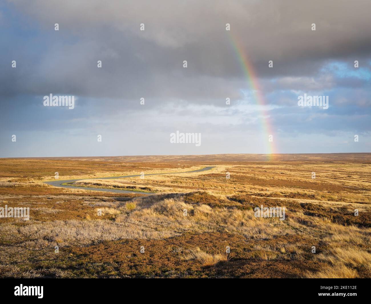 Arcobaleno sulla strada tortuosa a capo della valle di Rosedale, North York Moors Foto Stock