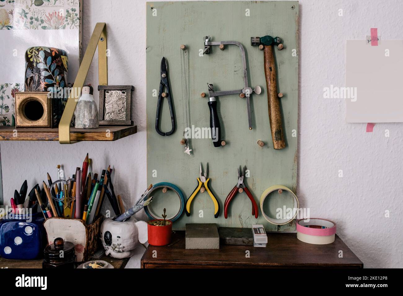 Attrezzature e attrezzature da lavoro appese a bordo a parete Foto Stock