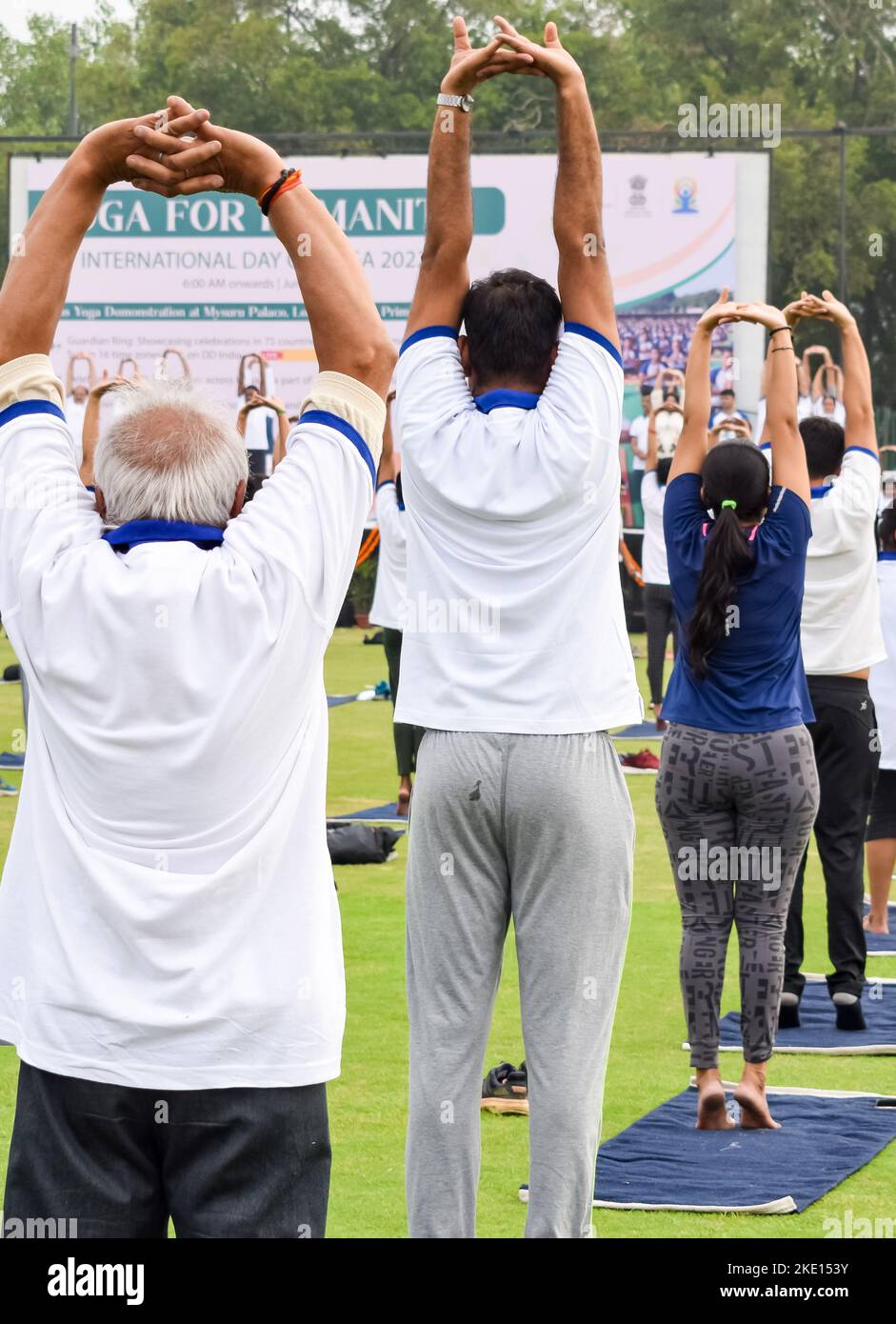 Sessione di esercizi di Group Yoga per persone di diverse età allo stadio di cricket a Delhi in occasione della Giornata Internazionale di Yoga, un grande gruppo di adulti che frequentano Yo Foto Stock