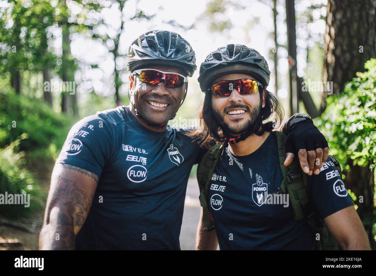 Ciclista maschile sorridente indossando occhiali e casco Foto Stock