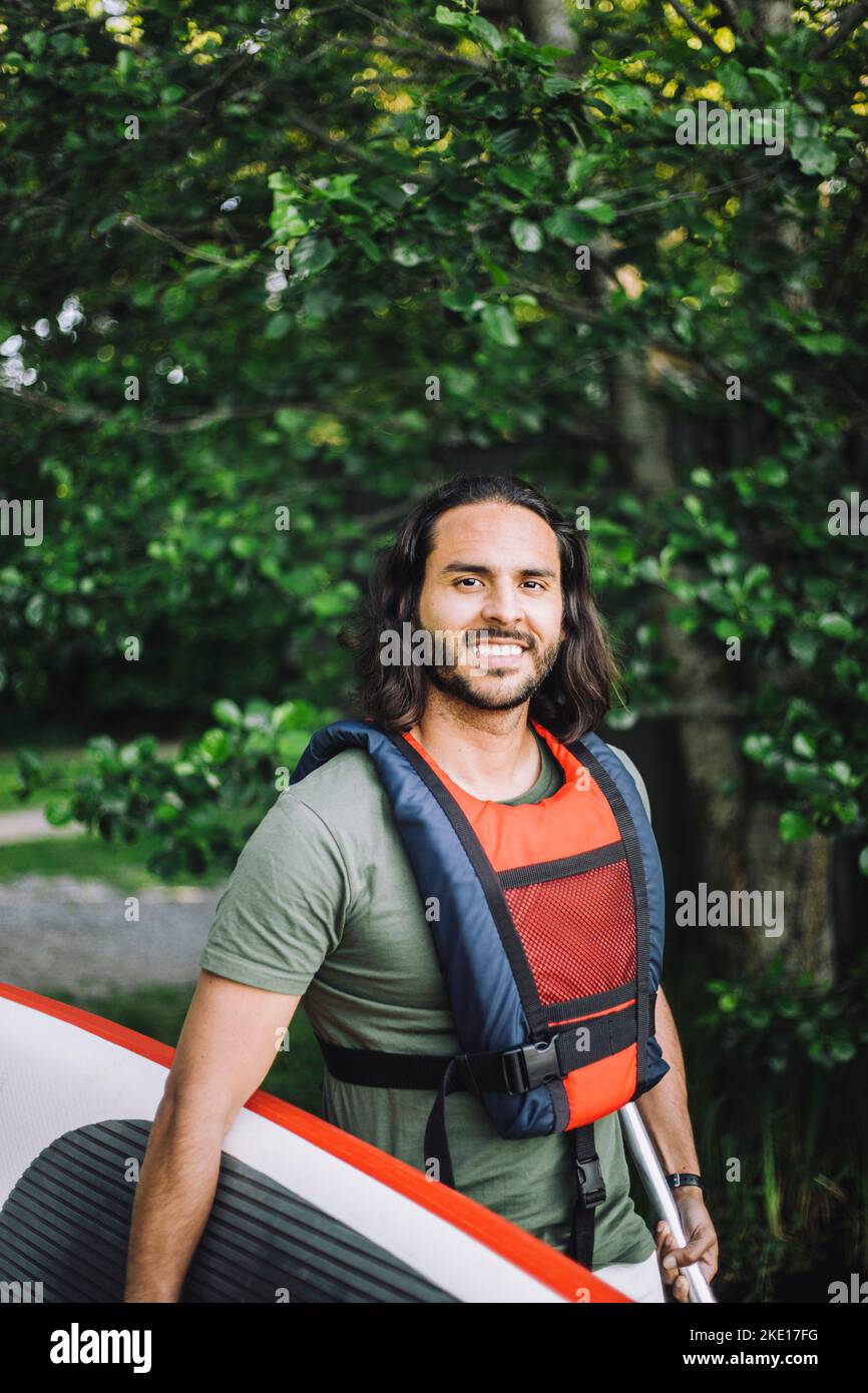 Ritratto di un uomo sorridente che tiene la tavola da tavola Foto Stock