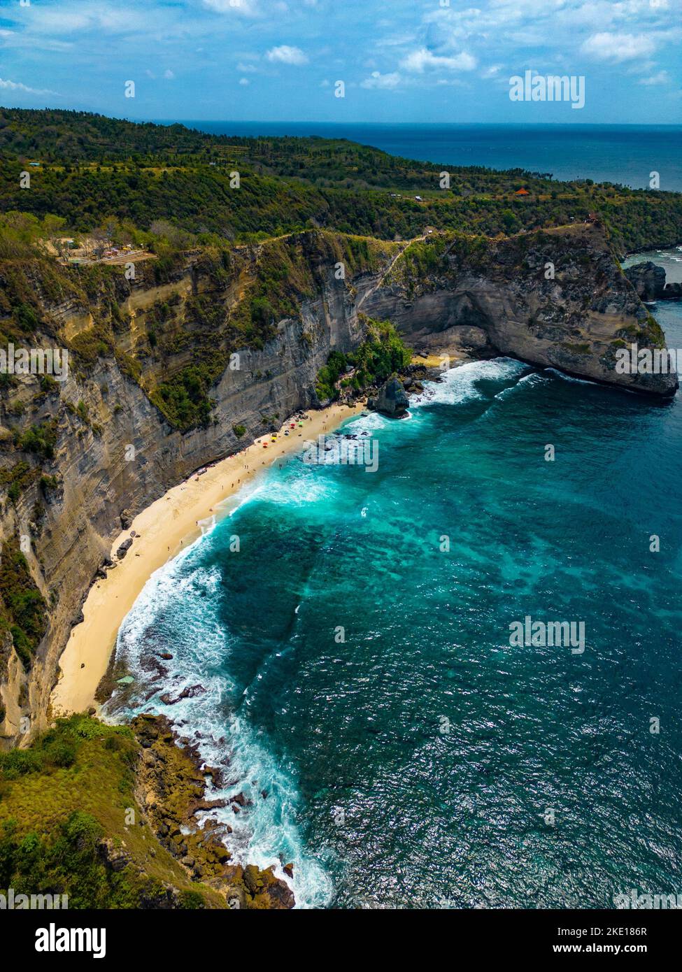 Un'antenna verticale della spiaggia di Suwehan con scogliere rocciose e boscose intorno e un cielo nuvoloso sfondo Foto Stock