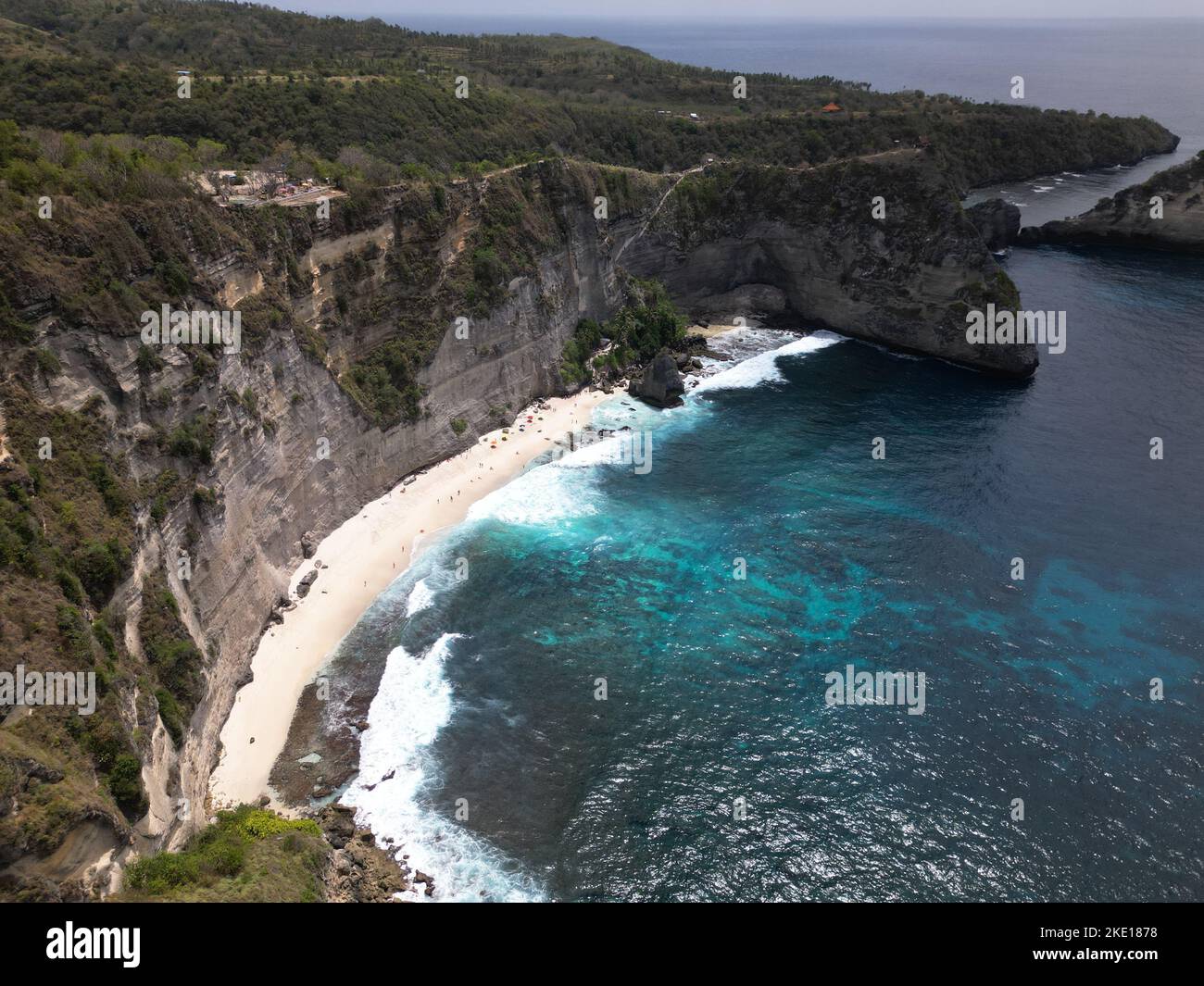 Un'antenna della spiaggia di Suwehan con scogliere rocciose e boscose intorno e un cielo nuvoloso sfondo Foto Stock