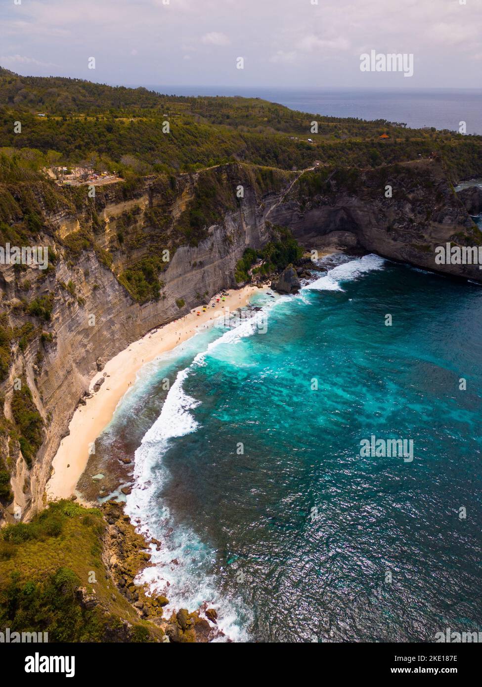 Un'antenna verticale della spiaggia di Suwehan con scogliere rocciose e boscose intorno e un cielo nuvoloso sfondo Foto Stock