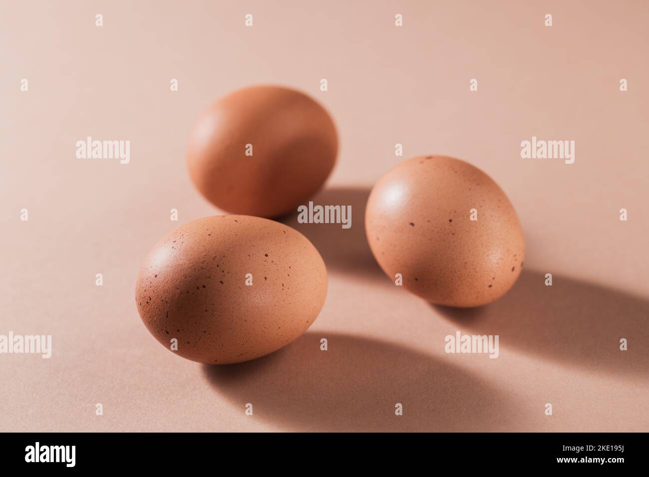 Uova di pollo marroni su sfondo beige. Foto Stock