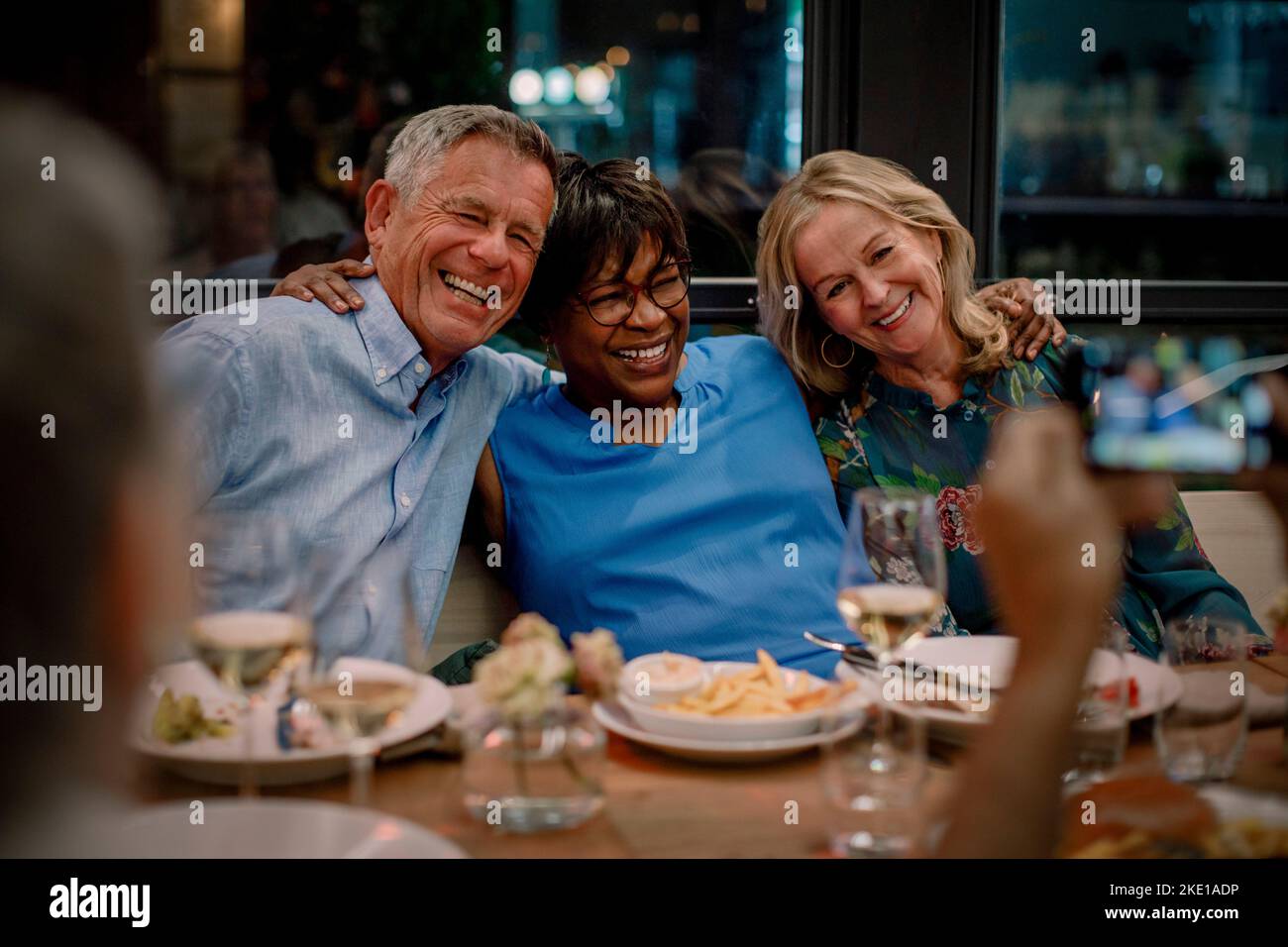 Amici maschi e femmine felici che si divertano al ristorante durante la notte Foto Stock