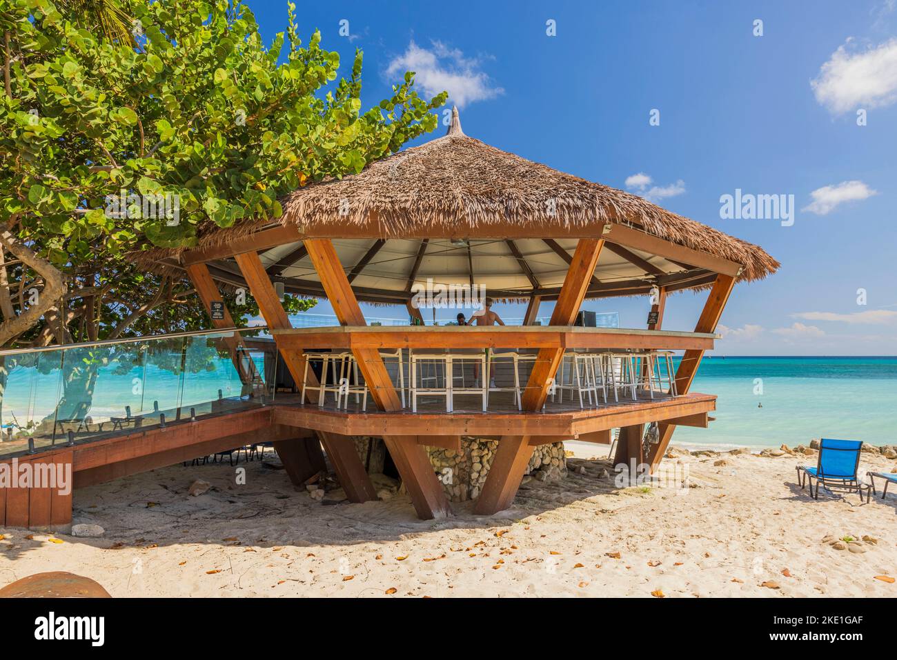 Splendida vista del bar all'aperto sulla spiaggia di sabbia. Acque turchesi dell'oceano Atlantico e cielo blu con nuvole bianche posteriori sullo sfondo. Aruba. Foto Stock