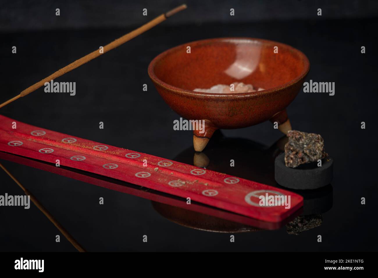 Bastone aromatico e gomma olibanum su tavola nera lucida Foto Stock