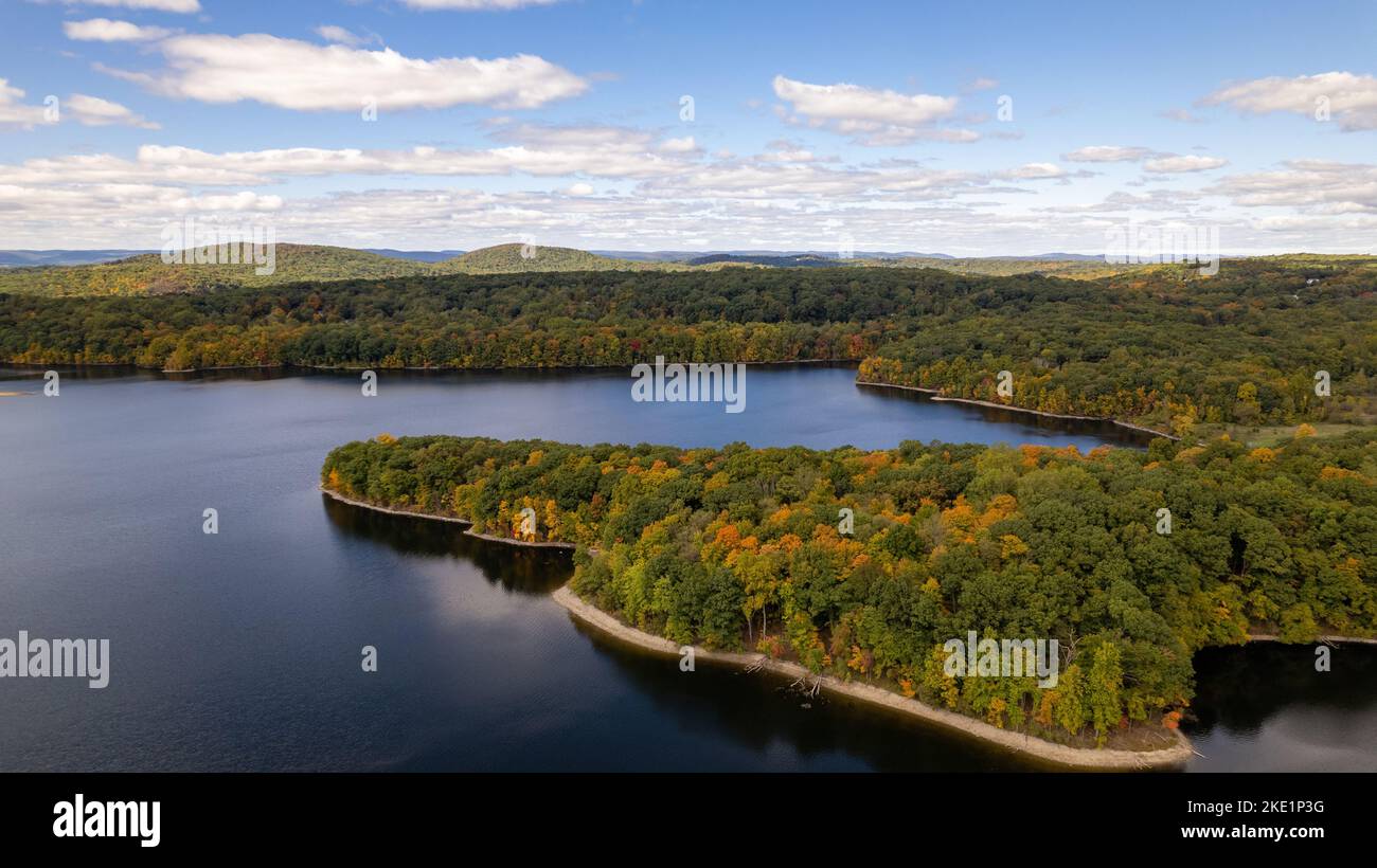 Un colpo di drone della riserva di New Croton in una giornata di sole in autunno con un cielo nuvoloso blu Foto Stock