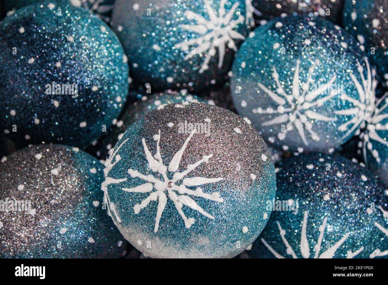 Primo piano delle palle di vetro dell'albero di Natale in blu con stella di Natale in argento e bianco, con rhinestones e paillettes. Sfondo di Natale. Foto Stock