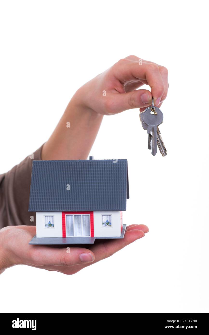 Una mano umana che tiene la propria casa con la chiave dell'appartamento Foto Stock