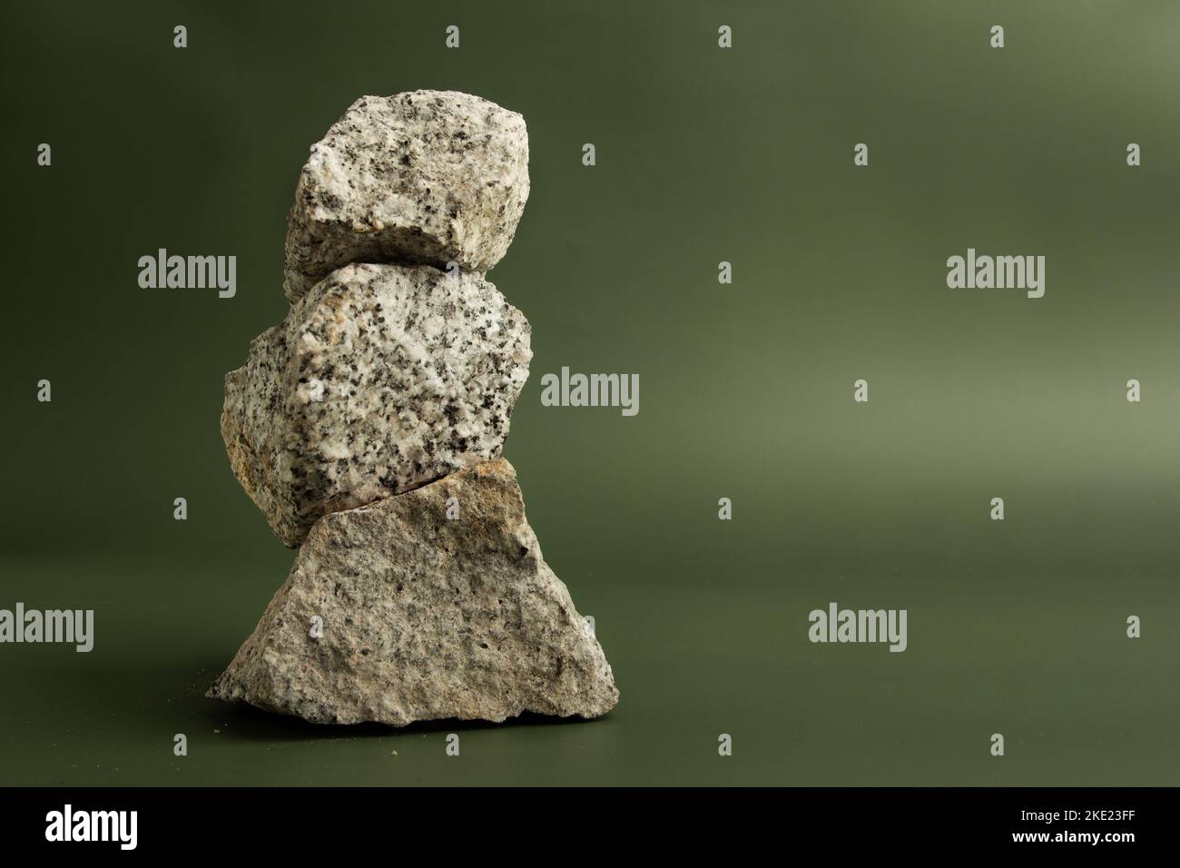 pietre di granito impilate su uno sfondo verde con spazio copia Foto Stock