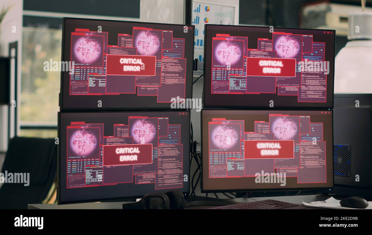 Ufficio vuoto con più monitor che mostrano un avviso di attacco hacking, agenzia IT che si occupa di un avviso di violazione della sicurezza. Messaggio di errore critico lampeggiante sullo schermo e malfunzionamento del computer. Foto Stock