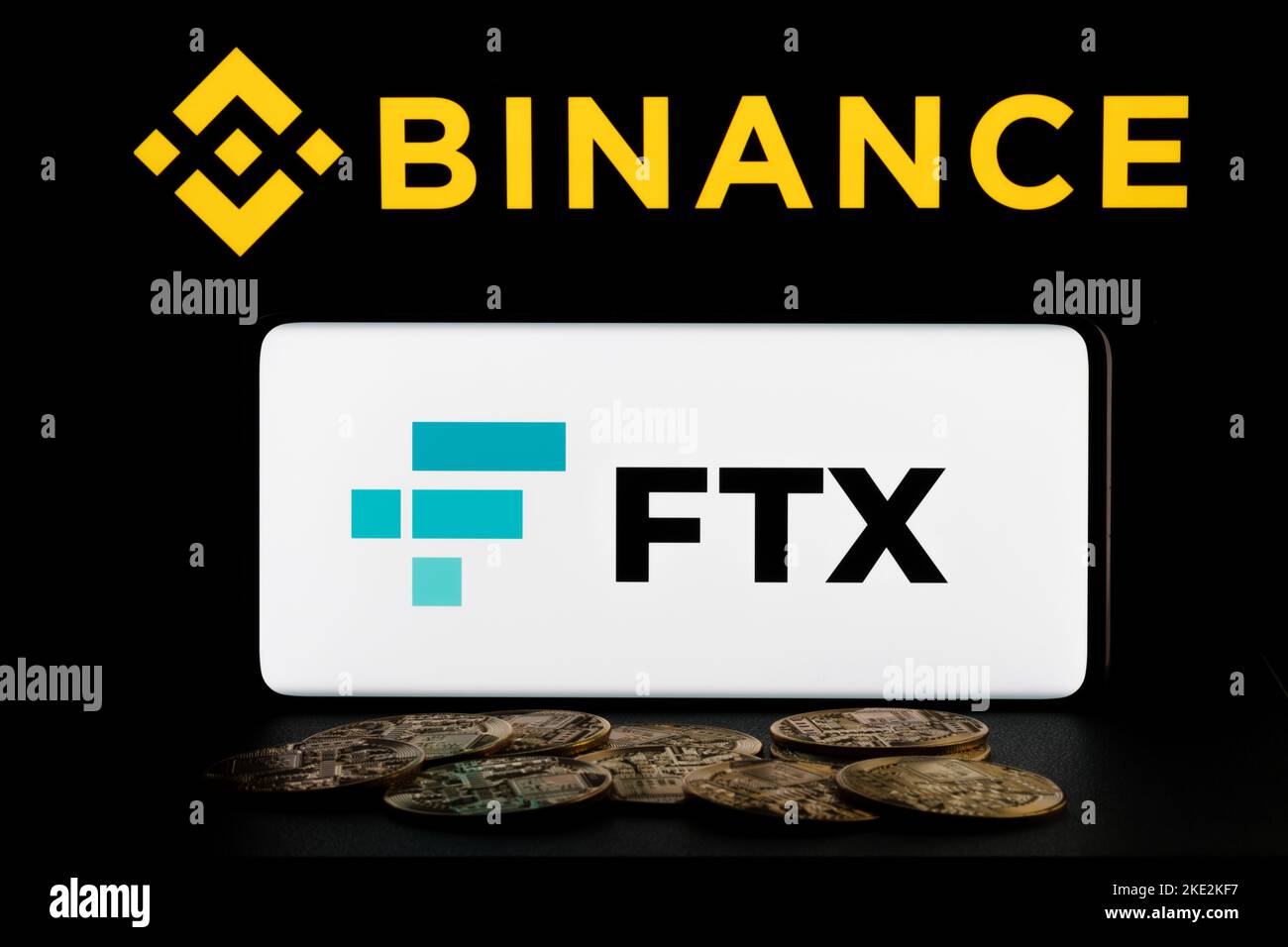 Concetto di fusione Binance e FTX Cryptocurrency Exchange. Logo FTX visualizzato sullo smartphone e logo sfocato Binance sul laptop. Stafford, United Kindom, North Foto Stock