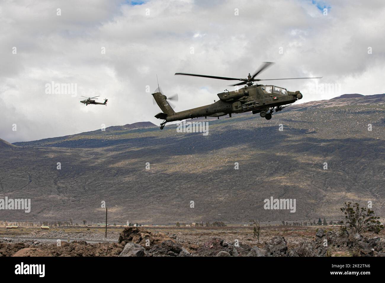 Gli elicotteri dell'esercito degli Stati Uniti Boeing AH-64 Apache con lo Squadrone 2nd, il reggimento di cavalleria 6th, la Brigata dell'aviazione di combattimento 25th, la divisione di fanteria 25th, volano sopra un punto di rifornimento durante l'addestramento alla zona di addestramento di Pohakuloa, Hawaii, 3 novembre 2022. Il Joint Pacific Multinational Readiness Center 23-01 è una rotazione di formazione realistica che ci permette di provare il movimento strategico e di allenarci in ambienti e condizioni unici in cui è più probabile che vengano impiegati in caso di crisi o conflitto. (STATI UNITI Foto dell'esercito di Sgt. Rachel Christensen/28th distaccamento degli affari pubblici) Foto Stock