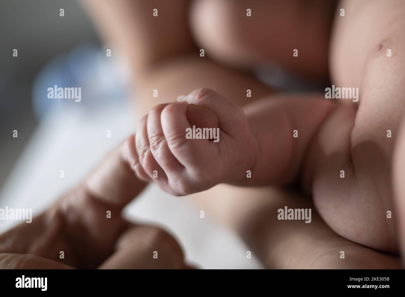 Neonato tenendo il dito del papà stretto con la mano in posizione selettiva. Foto Stock