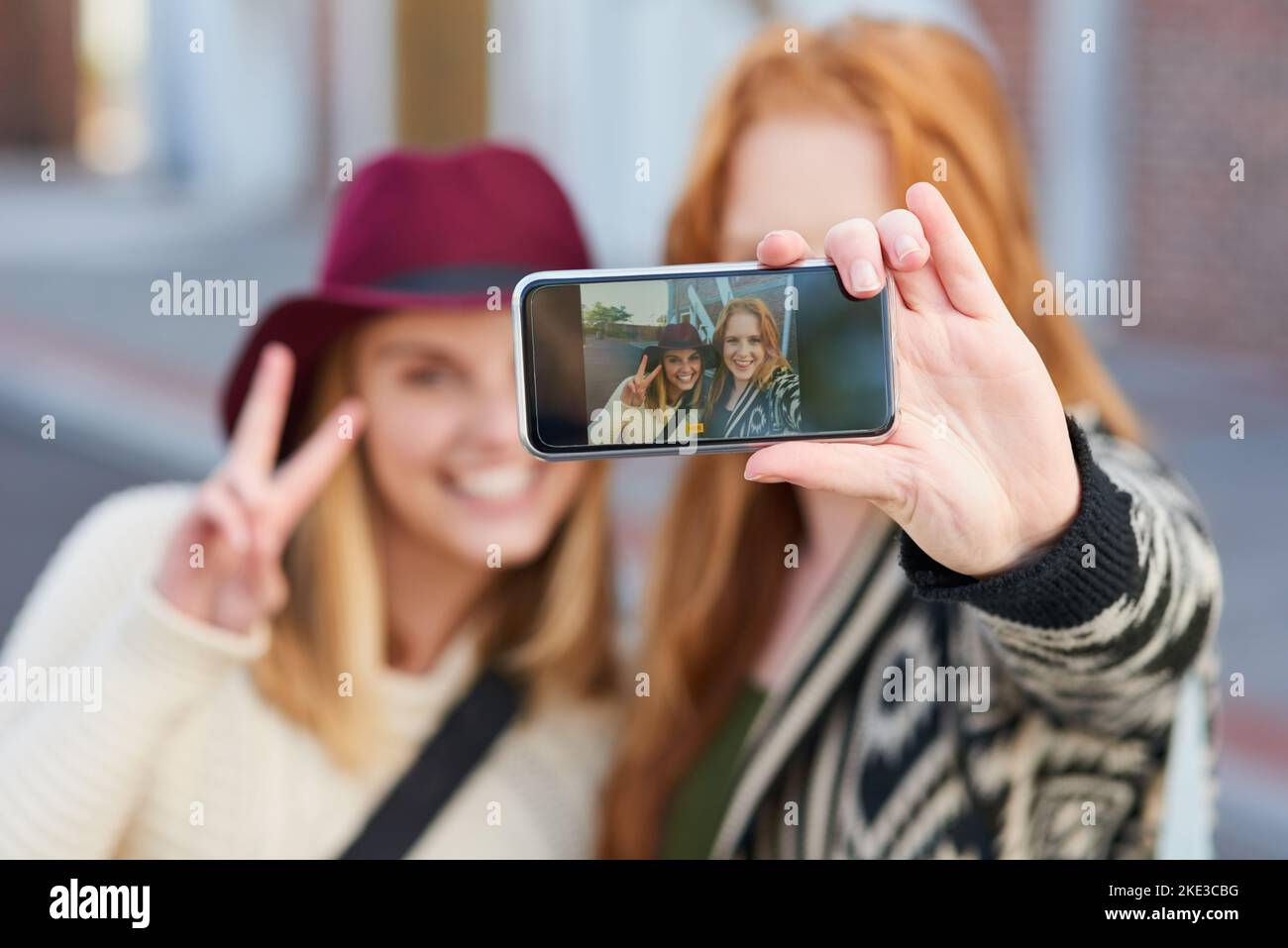 Guardate questi ricordi: Due studenti universitari che prendono un selfie insieme nel campus. Foto Stock