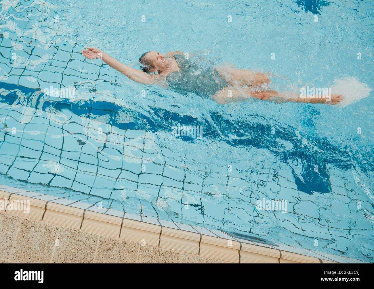 Donna anziana, piscina e pensione felice, stile di vita sano o sport benessere in estate all'aperto. Vecchia donna che fa il backstroke in acqua per Foto Stock