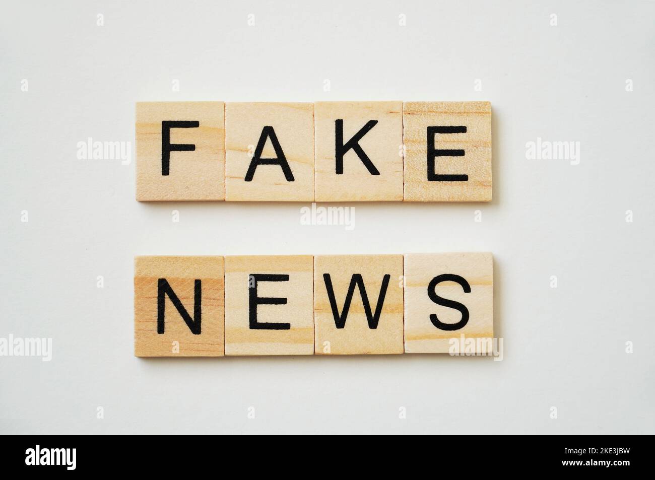 Notizie false. Scritta nera su piatti di legno. Sfondo bianco. Foto Stock