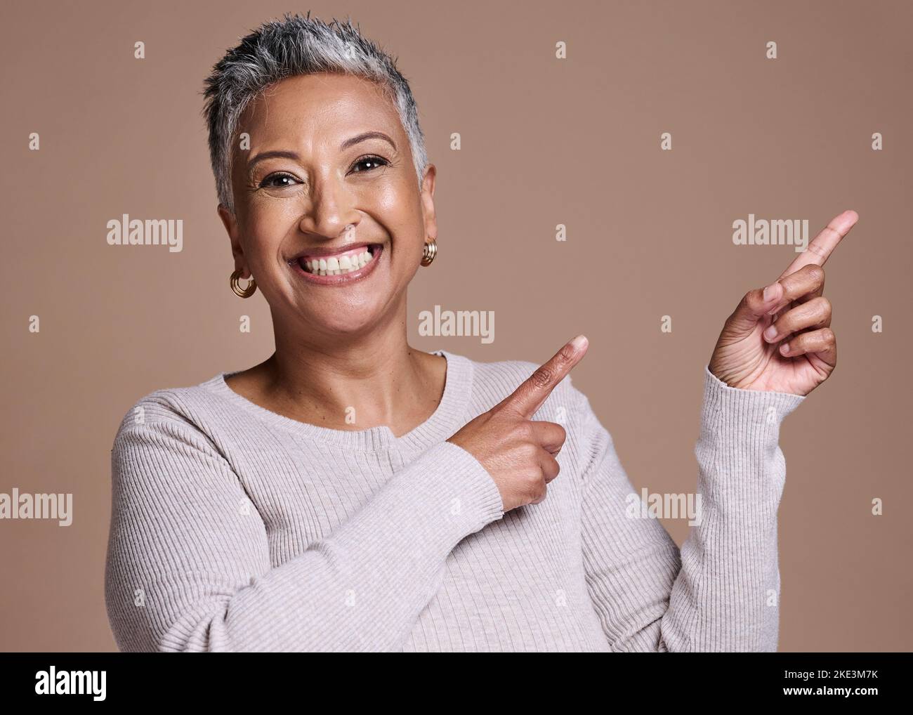 Donna, sorriso e felicità in studio per la pubblicità spazio libero, promo o mockup su uno sfondo marrone per cosmetici, trucco o moda. Ritratto del volto Foto Stock
