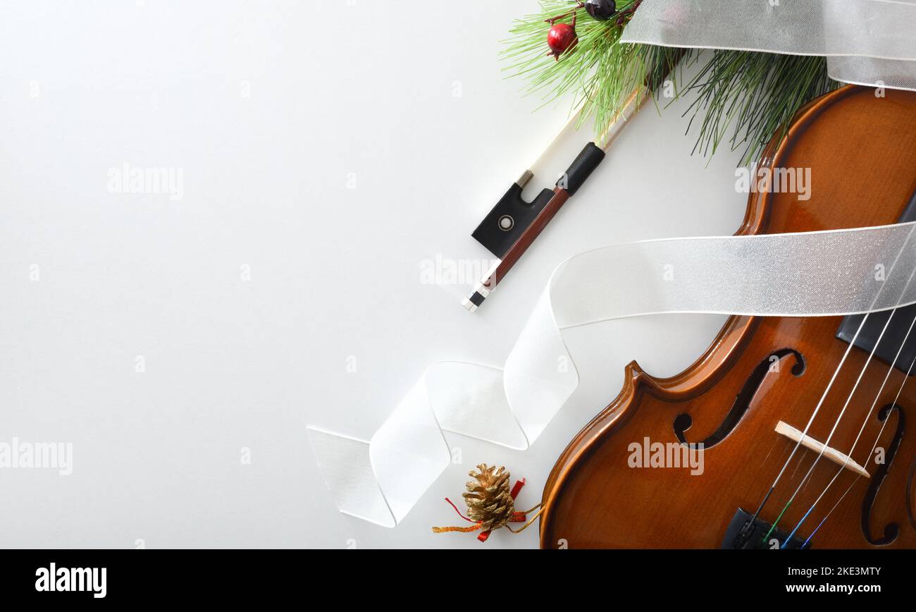 Evento musicale di Natale concept sfondo con violino e decorazione su tavolo bianco. Vista dall'alto. Foto Stock