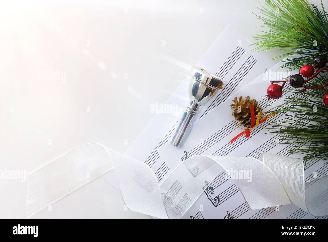 Concerto di Natale di strumenti in ottone con boccaglio e spartiti su tavolo bianco. Vista dall'alto. Foto Stock