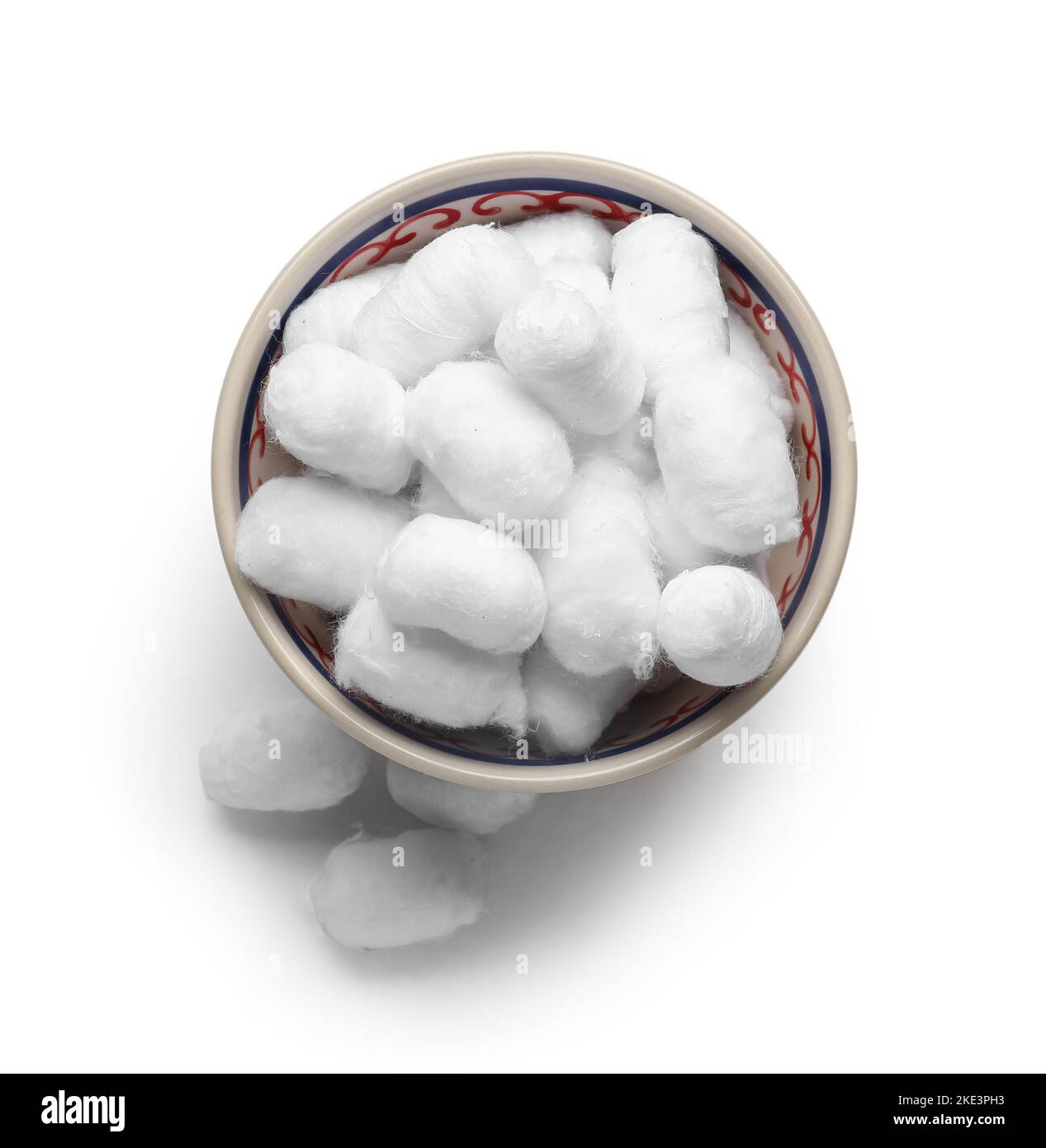 Ciotola di palle di cotone morbide su sfondo chiaro Foto Stock