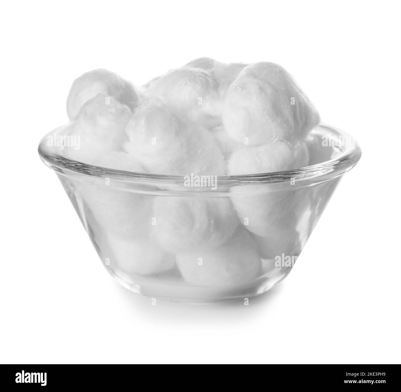 Ciotola di morbide palle di cotone su fondo bianco Foto Stock