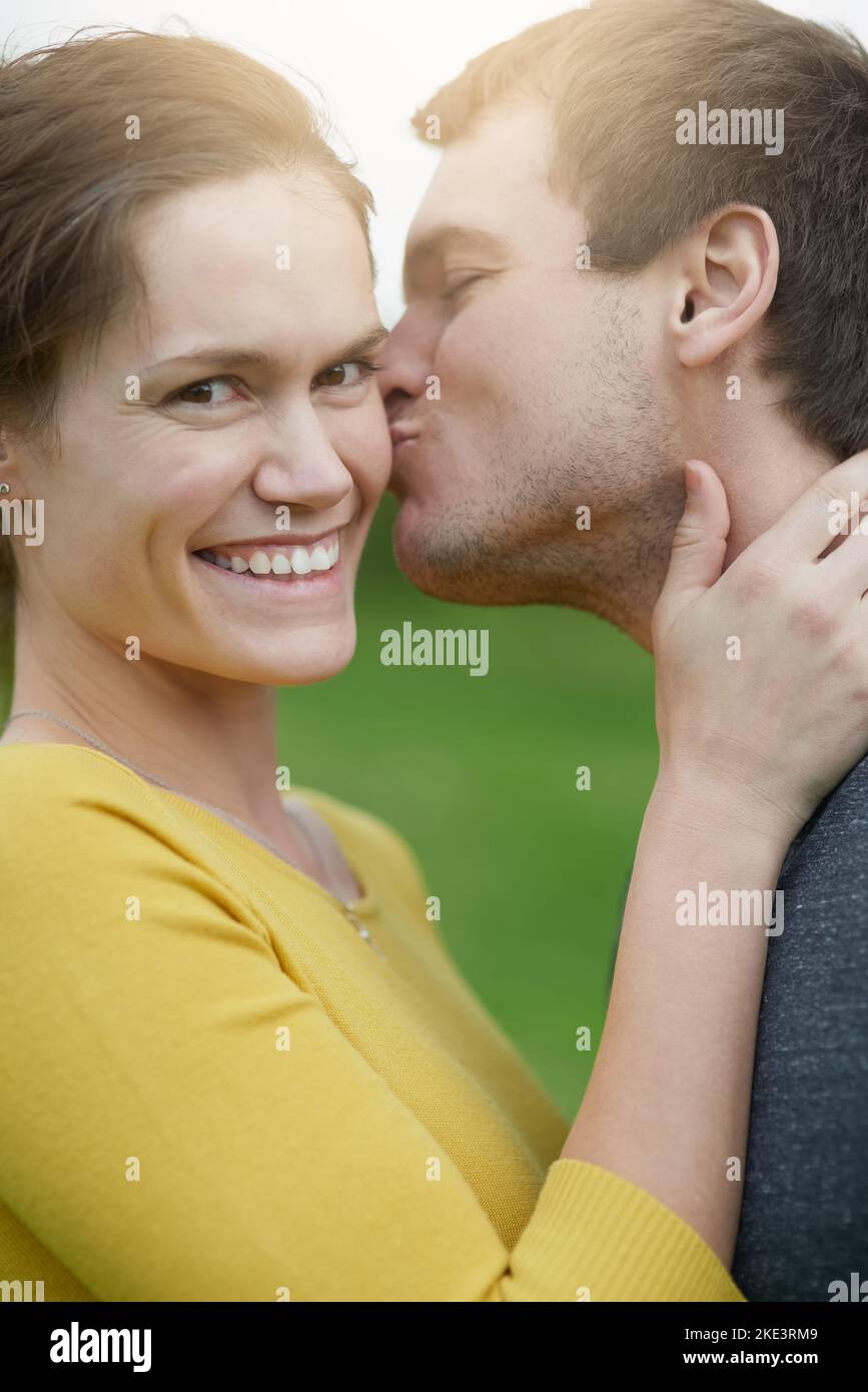 Non riuscì a resistere ad un altro bacio, una donna felice che riceveva un bacio dal marito fuori. Foto Stock