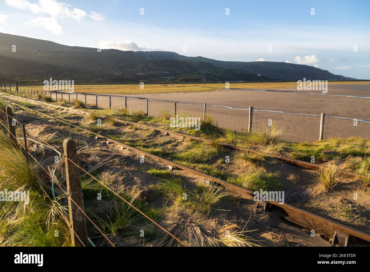 Linea ferroviaria coperta di sabbia soffiata dalla vicina spiaggia di Barmouth, Galles. Foto Stock