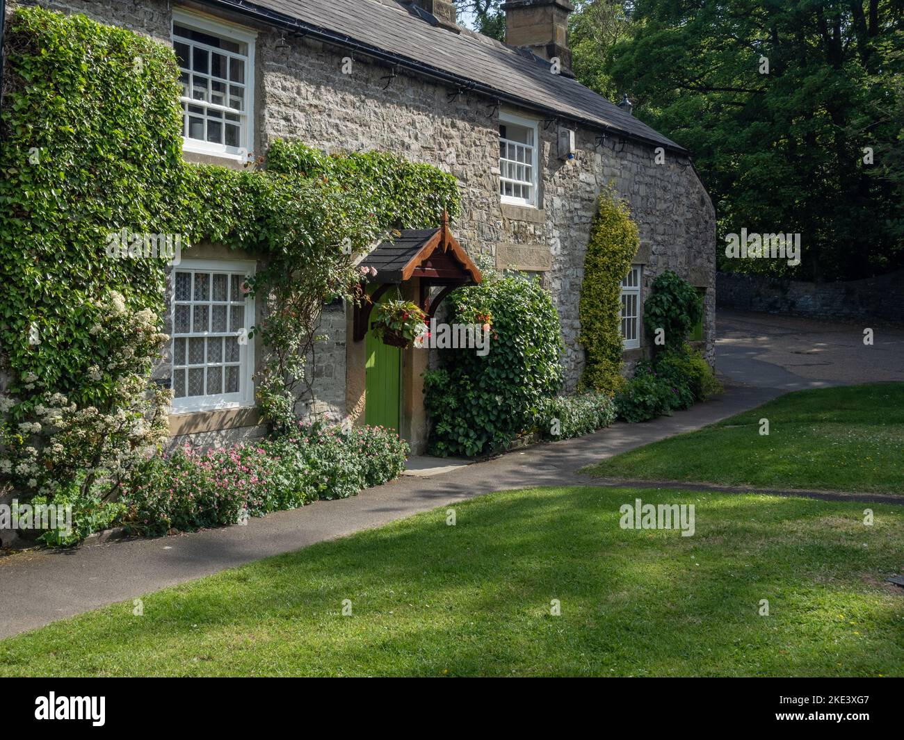 L'attraente Bridge House, un cottage costruito in pietra sul verde nel villaggio di Ashford in the Water, Derbyshire, Regno Unito Foto Stock