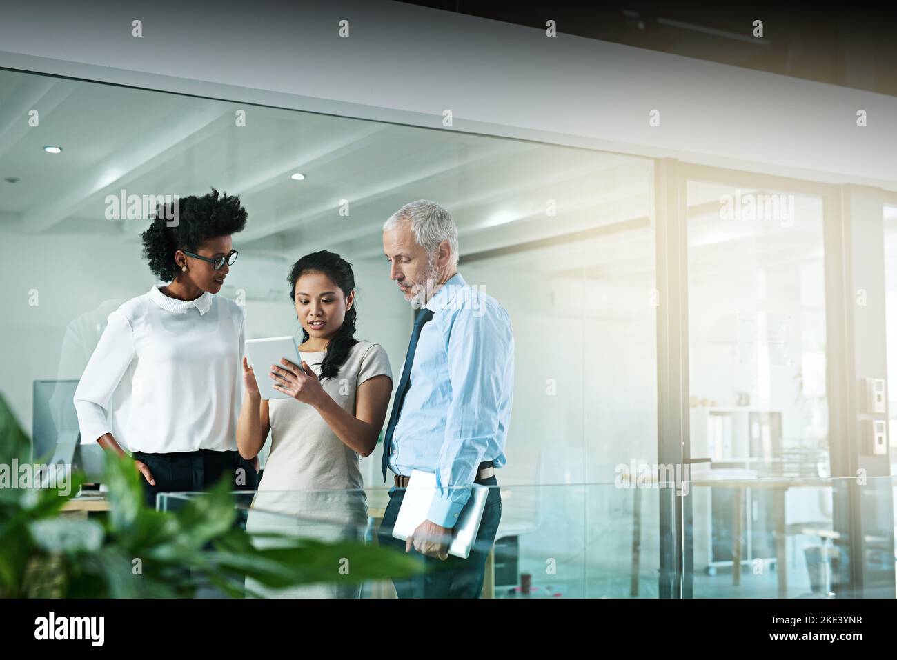 I punti di forza di una persona riguarderanno altri punti deboli, il lavoro di squadra. Un team aziendale che utilizza un tablet digitale mentre si terrà una riunione informale. Foto Stock