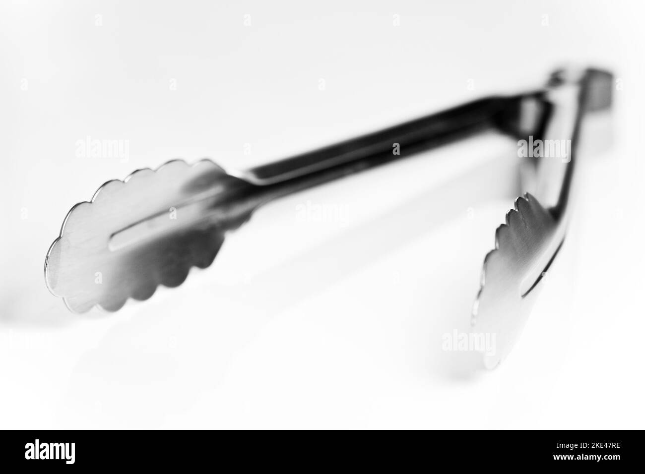 Pinze aperte isolate su sfondo bianco con profondità di campo bassa. Foto Stock