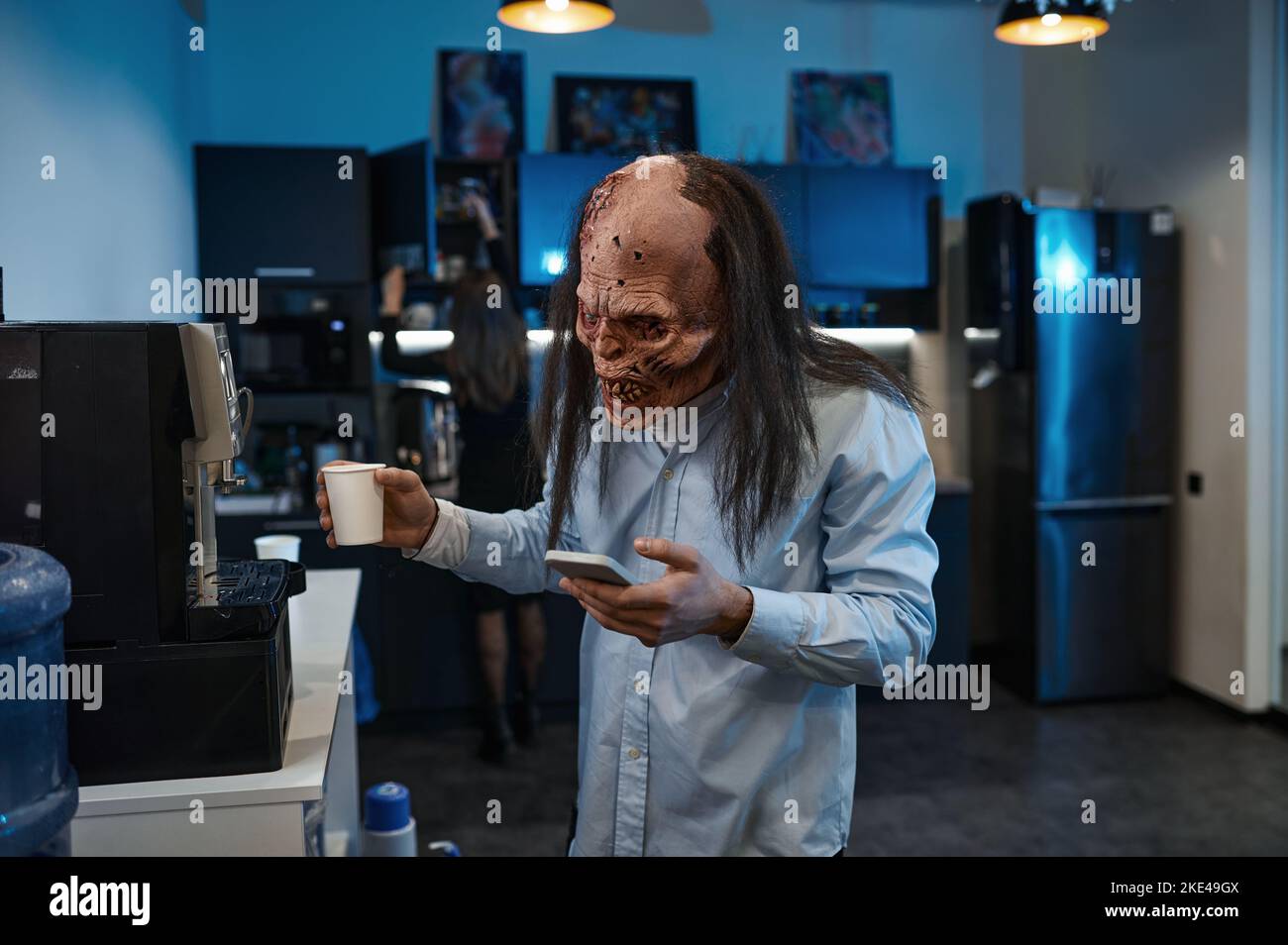 Lavoratore zombie fare caffè e parlare telefono cellulare Foto Stock