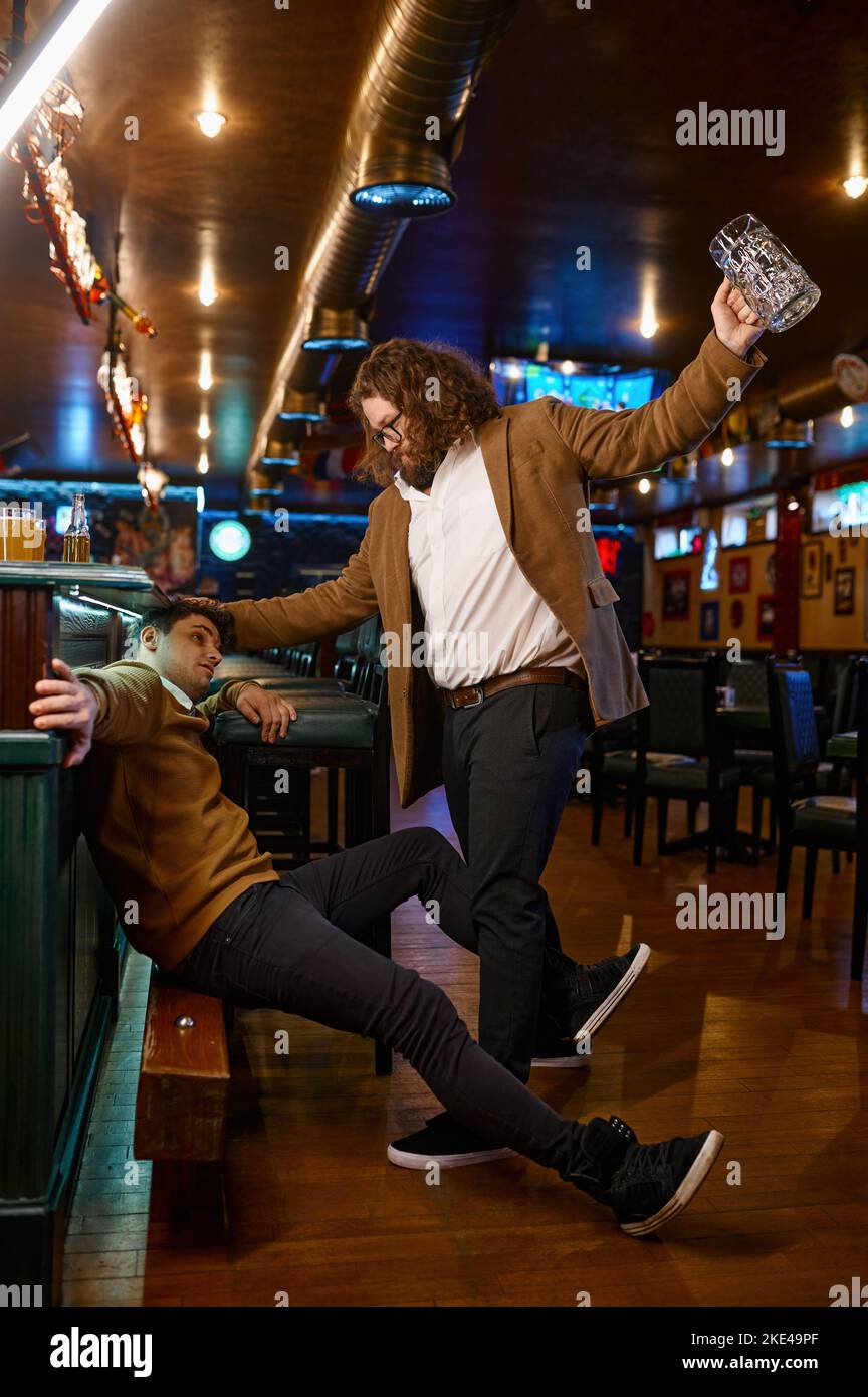 Infelici amici che combattono al pub Foto Stock