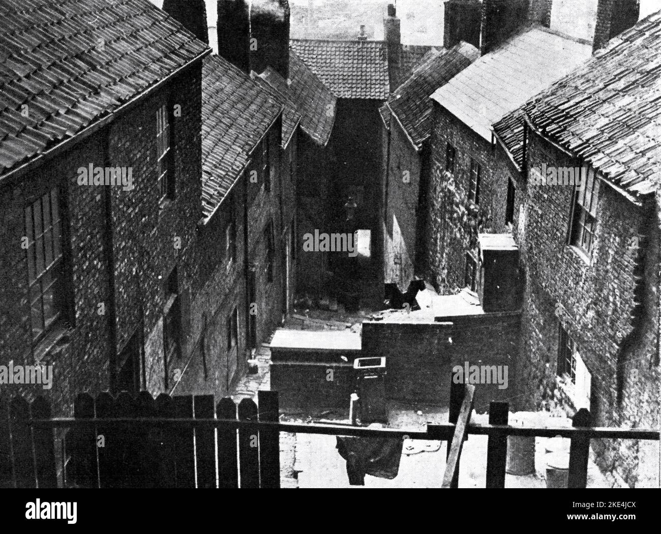 Slum cortile nella città industriale settentrionale, Inghilterra, 1933. La bonifica delle baraccopoli nel Regno Unito è stata utilizzata come strategia di rinnovamento urbano per trasformare le aree più povere. Nelle città settentrionali del paese si svolsero le prime raduno di massa. A partire dagli anni '1930s, con il Housing Act del 1930, i consigli dovevano preparare piani per eliminare le abitazioni degli slum, anche se i progressi si sono arenati con l'inizio della seconda guerra mondiale Foto Stock