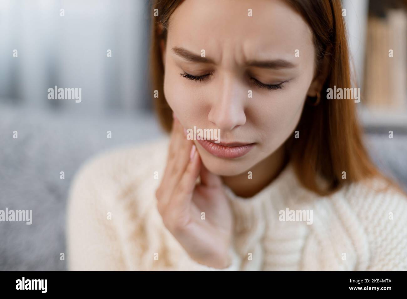 Donna con mal di denti a casa Foto Stock