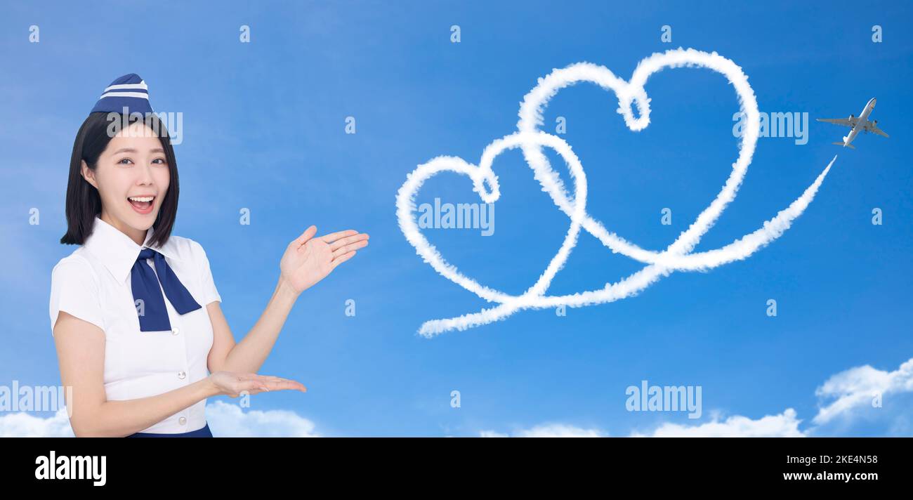 Bella stewardess che mostra l'amore e il concetto di viaggio di luna di miele su sfondo blu Foto Stock