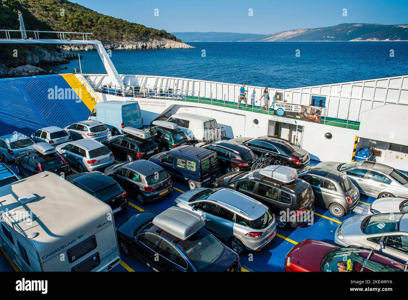 Le auto vengono trasportate su un traghetto dalla terraferma all'isola in Croazia Foto Stock