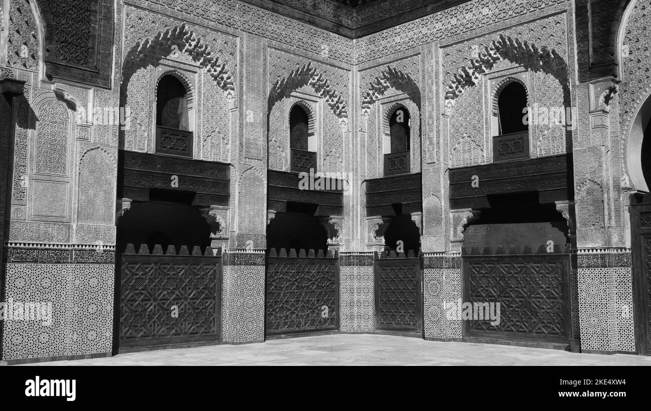 Una scala di grigi delle pareti di Madrasa ricoperte di intricate sculture islamiche e belle decorazioni Foto Stock