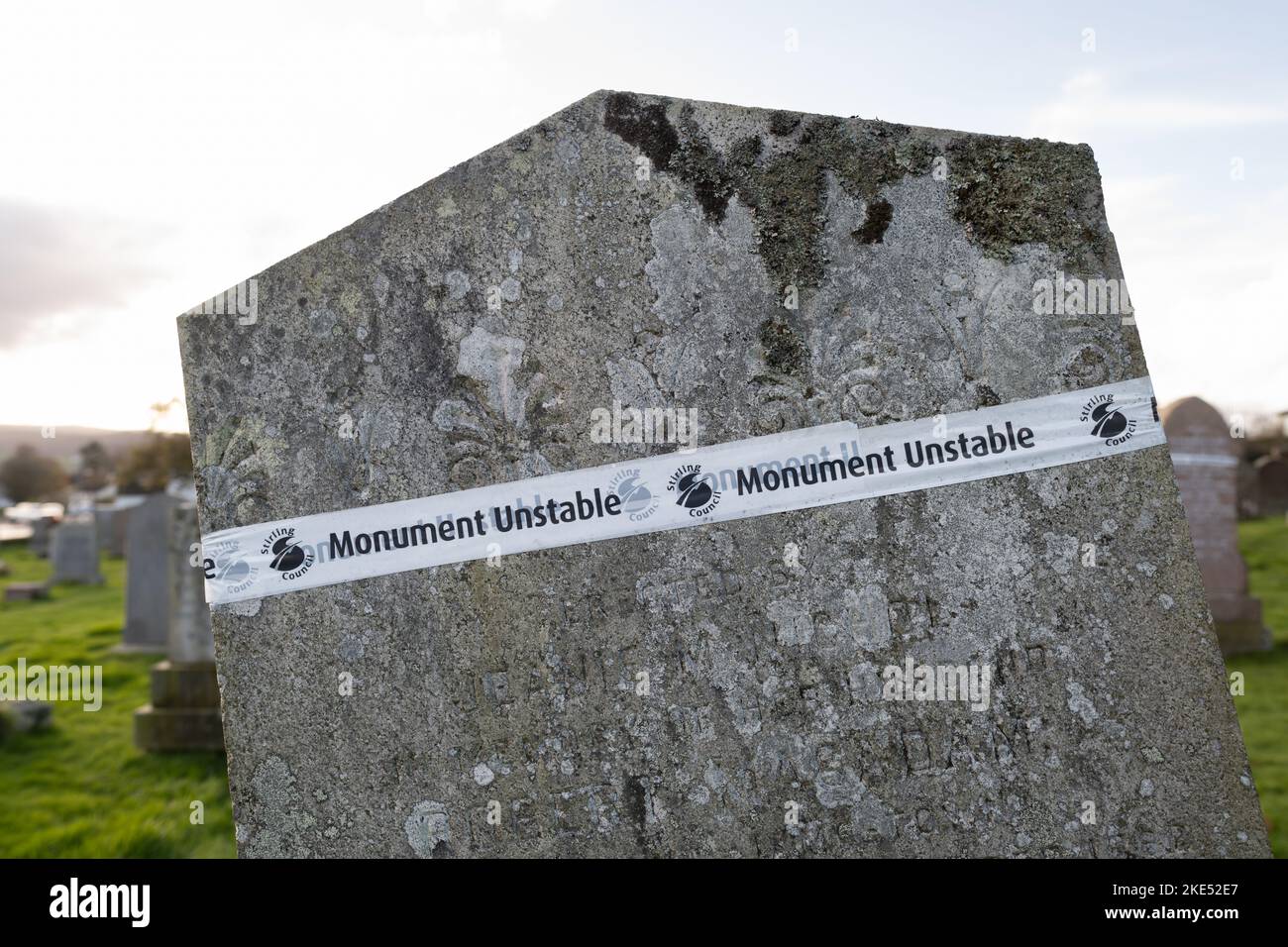 Monument unstable Stirling Council tape avvolto intorno a headstone non sicuro in cimitero, Killearn, Stirling, Scozia, Regno Unito Foto Stock
