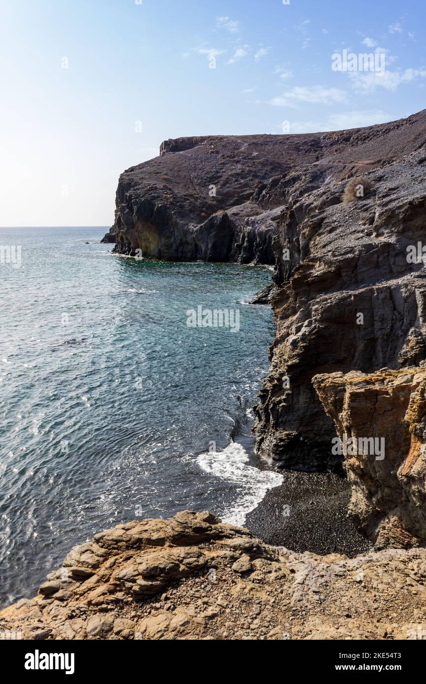 Costa rocciosa con cielo blu in una giornata di sole vicino a Playa Mujeres, Lanzarote, Isole Canarie, Spagna. Foto Stock