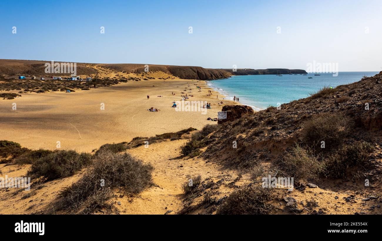 Spiaggia di sabbia dorata bagnata dalle acque cristalline turchesi dell'Oceano Atlantico a Playa Mujeres, Playa Blanca, Yaiza, Lanzarote, Las Palmas, Spagna Foto Stock