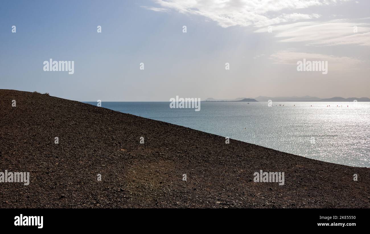 Spiaggia e mare contrasto sulla costa rocciosa vicino a Playa Mujeres, Playa Blanca, Yaiza, Lanzarote, Las Palmas, Isole Canarie, Spagna, Europa. Foto Stock