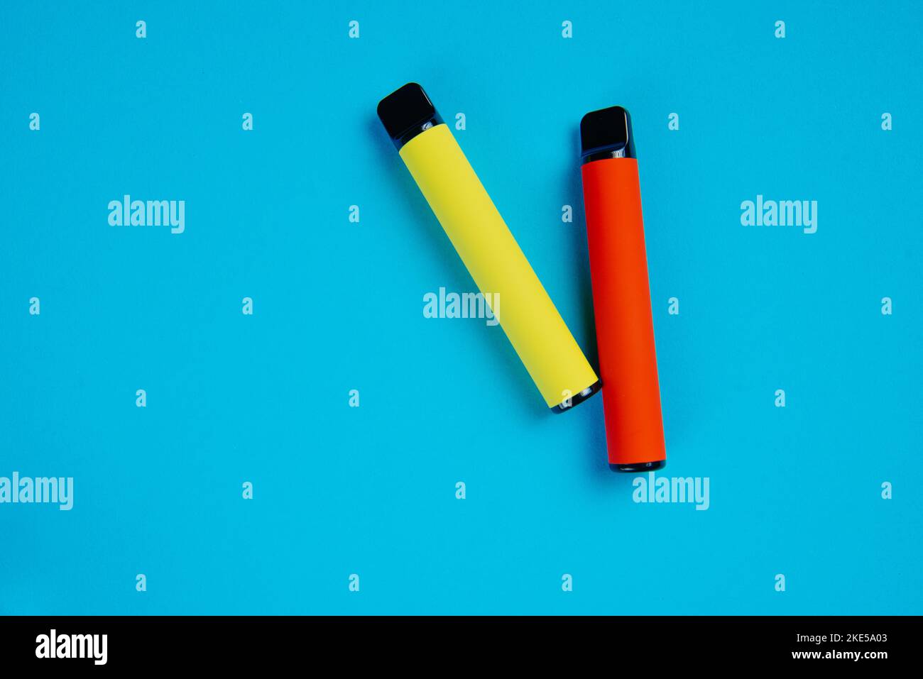 Due e-sigarette usa e getta su sfondo blu. Electronic vape, un'alternativa al fumo di sigarette. Foto Stock