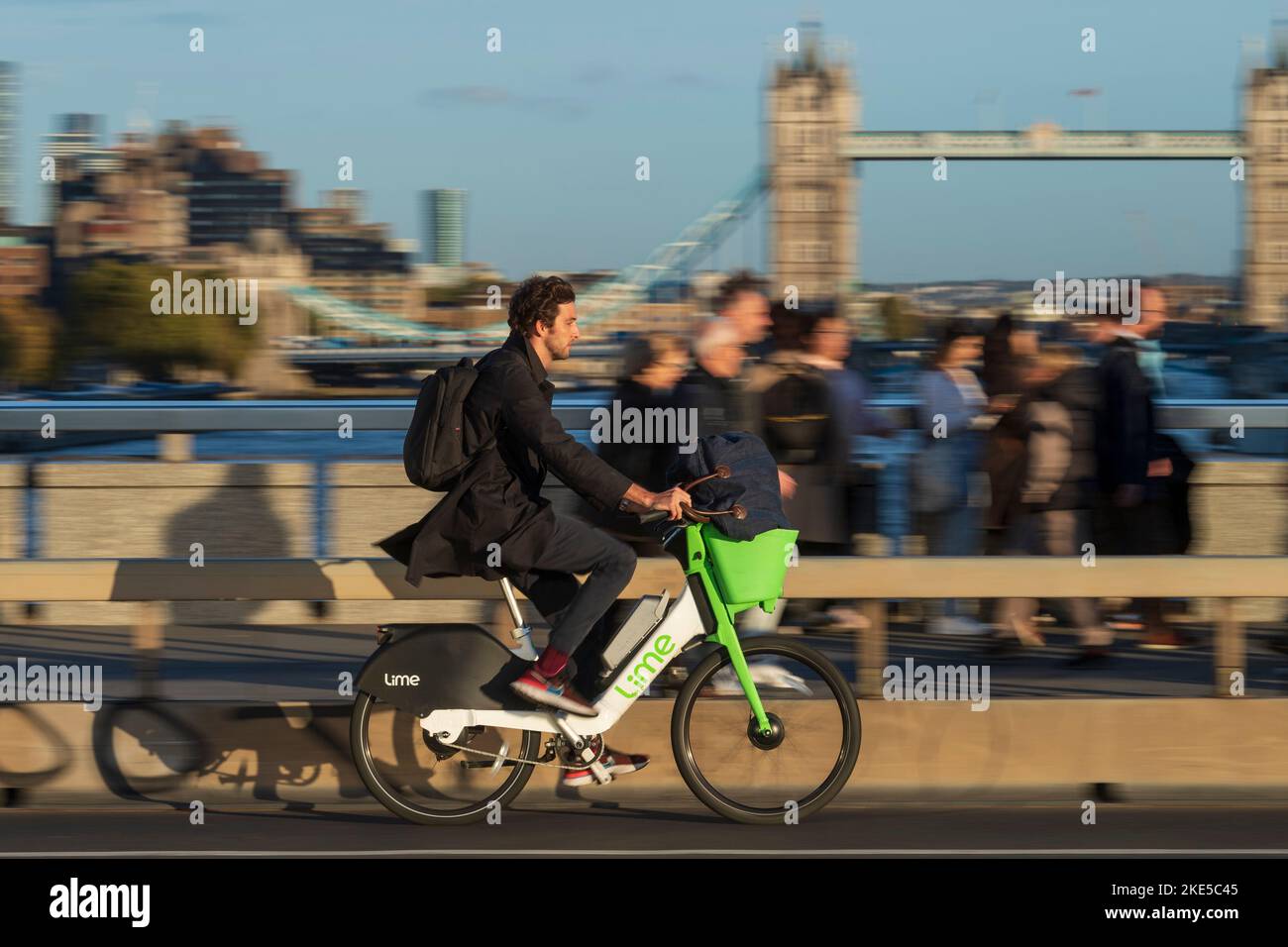 Un uomo che si trova a Londra durante l'ora di punta e che si trova a Londra durante il viaggio in bicicletta elettrica a noleggio. London Bridge, Londra, Regno Unito. 28 Ott 2022 Foto Stock