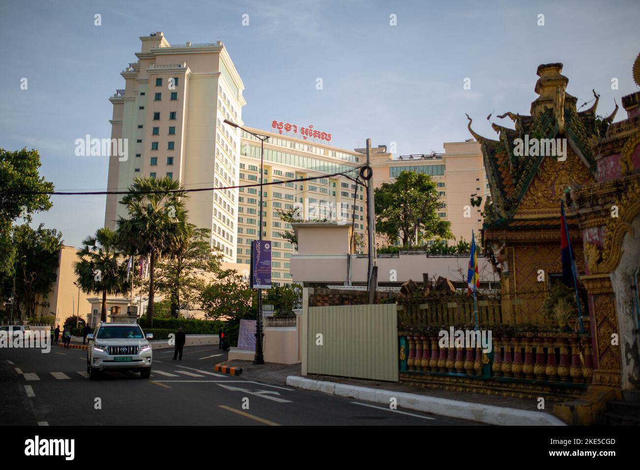Phnom Penh, Cambogia. 10th Nov 2022. Un veicolo parte dal Sokha Hotel, un tempio adiacente può essere visto in primo piano. Il vertice degli stati ASEAN si terrà dal 10 al 13 novembre. L'associazione dei paesi del sud-est asiatico comprende dieci paesi che collaborano principalmente nei settori economico, sociale e culturale. Quest'anno la Cambogia detiene la Presidenza. Credit: Chris Humphrey/dpa/Alamy Live News Foto Stock