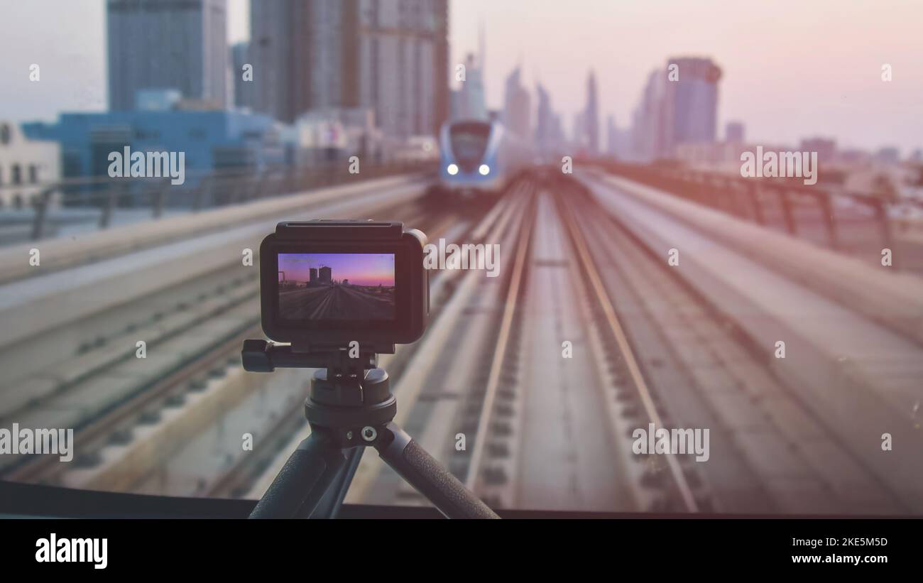 Fotocamera su treppiede pellicola time-lapse in Dubai metro posti anteriori. Panorama panoramico dello skyline della città riprese video per lo scatto sociale media.Commercial licen Foto Stock